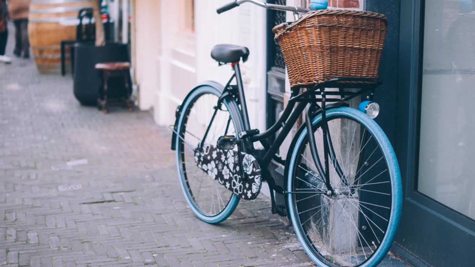 Citybike mit Weidenkorb vor einem Ladenfenster