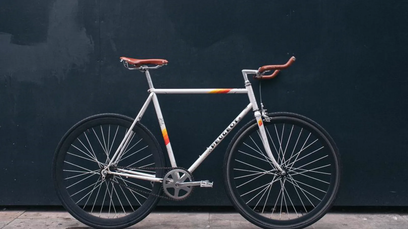 Helles Fahrrad vor einer dunklen Wand